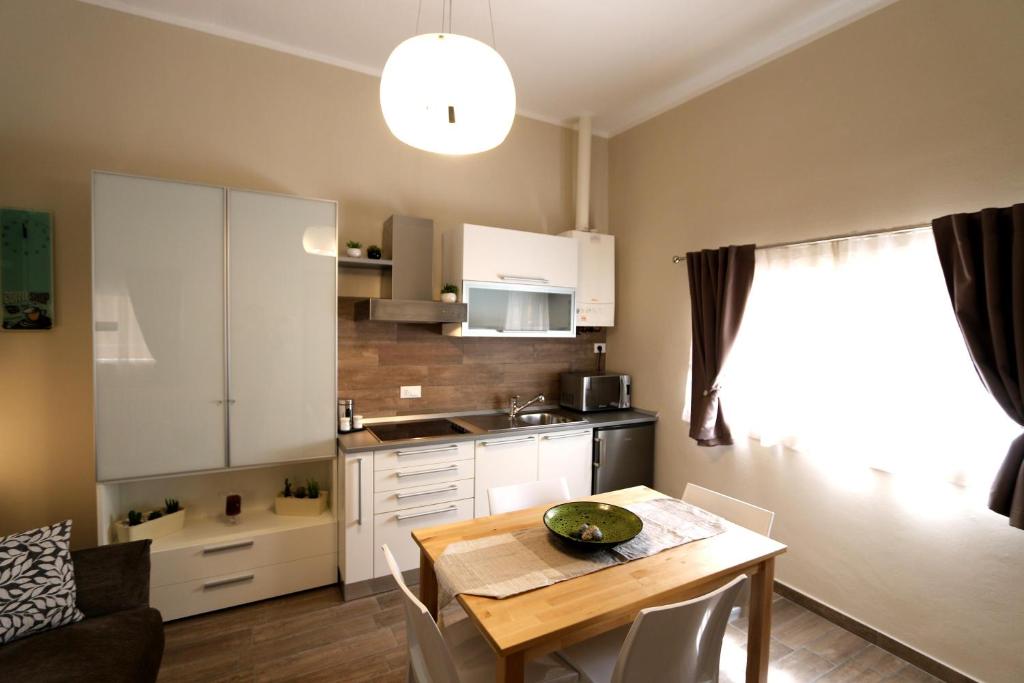 a kitchen with a table and a small kitchen with a dining room at Le Stanze Apartament in Bologna