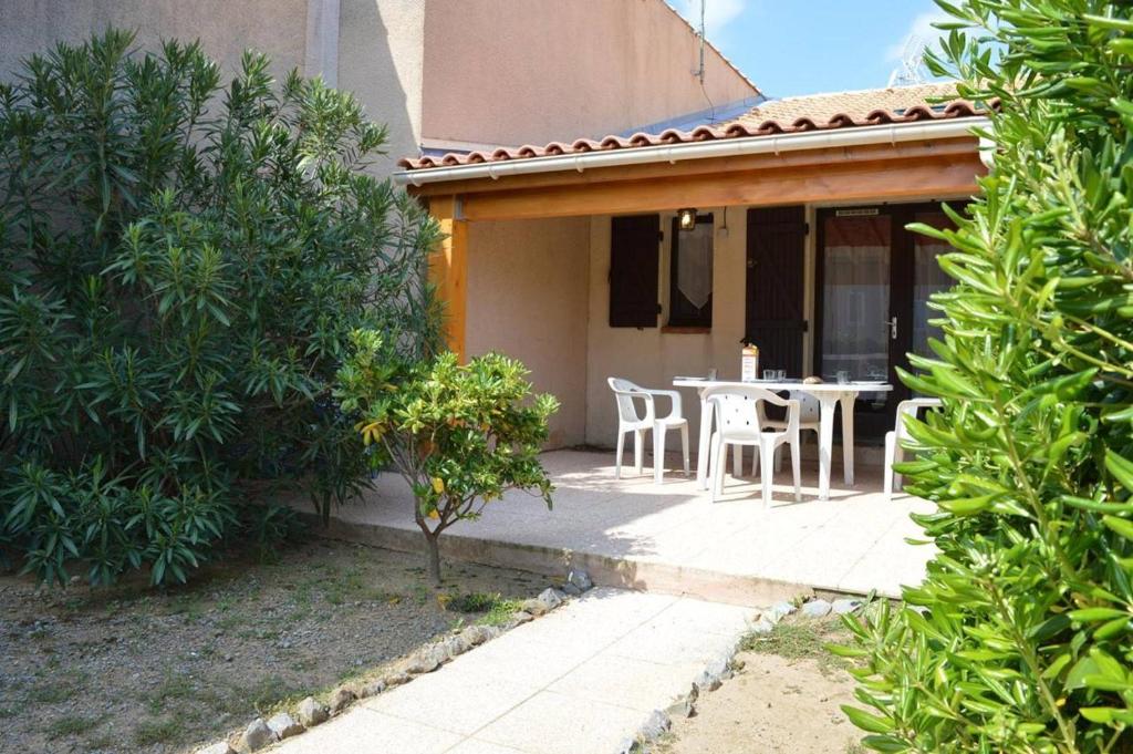 un patio d'une maison avec une table et des chaises dans l'établissement SP320-528 Maison 2 pièces mezzanine SAINT PIERRE LA MER, à Saint Pierre La Mer