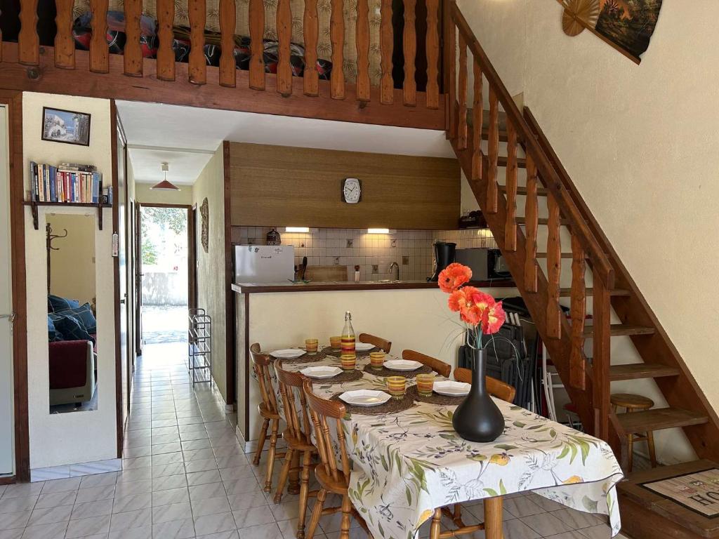 une salle à manger avec une table avec un vase de fleurs dans l'établissement SP330-027 Maison SAINT PIERRE LA MER, à Saint Pierre La Mer