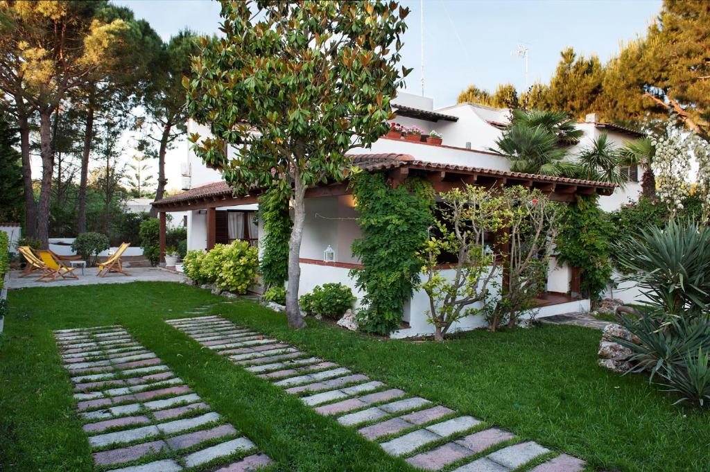 una casa con un cortile verde con un sentiero di B&B Canneto Beach a Leporano