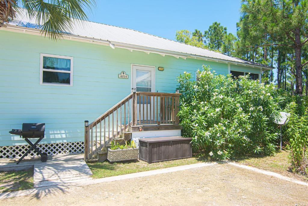 a blue house with a porch and a grill at 4014 Rookery 3 Cottage with two Pools and Beach Amenities in Gulf Highlands