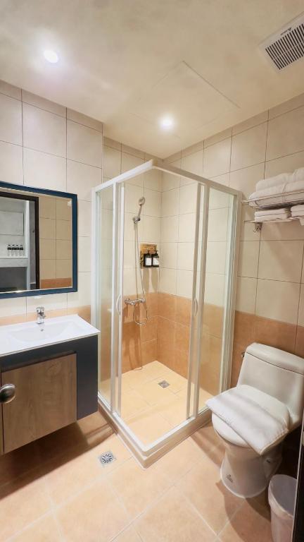 łazienka z prysznicem, toaletą i umywalką w obiekcie Hello inn 哈囉行旅屏東館 w mieście Pingdong