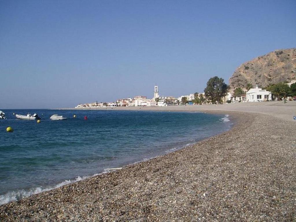 a rocky beach with boats in the water and houses at Refugio Costero Tu Hogar vistas al Mar con Parking in Calahonda