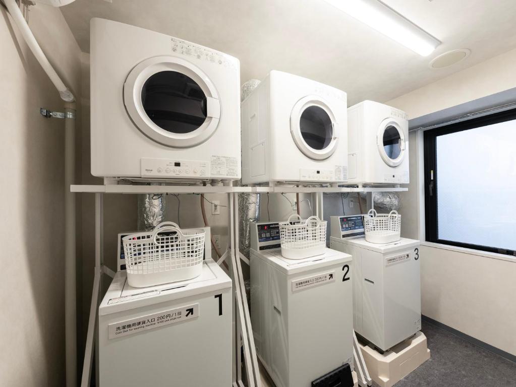 a room with four washing machines on a shelf at SUPER HOTEL Ikebukuro West Natural Hot Spring in Tokyo