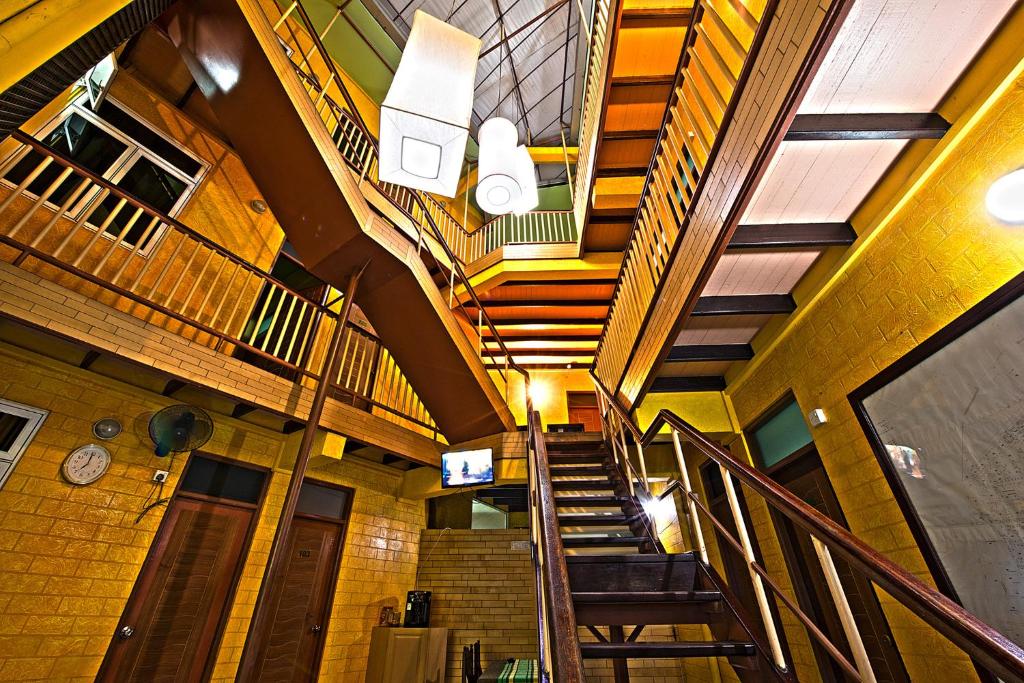 Un pasillo con escaleras en un edificio con un reloj. en The Park House, en Male