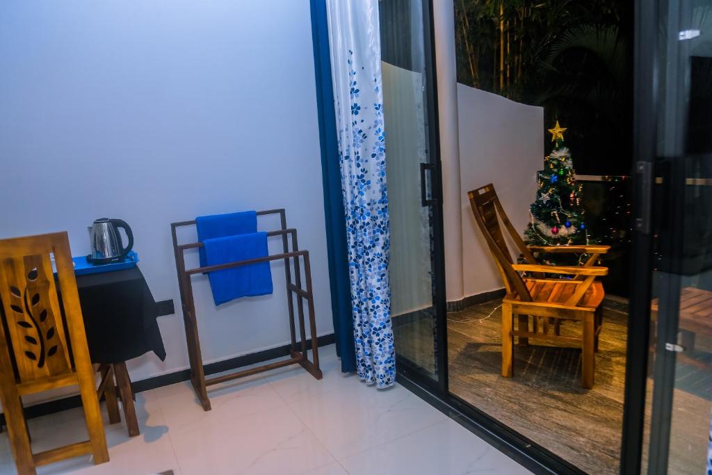 a room with a mirror and a chair and a christmas tree at Mirissa Breeze in Mirissa