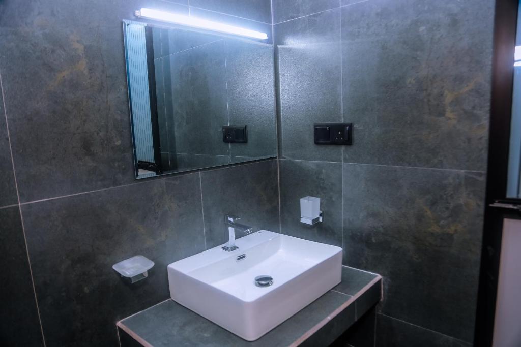 a bathroom with a white sink and a mirror at Mirissa Breeze in Mirissa