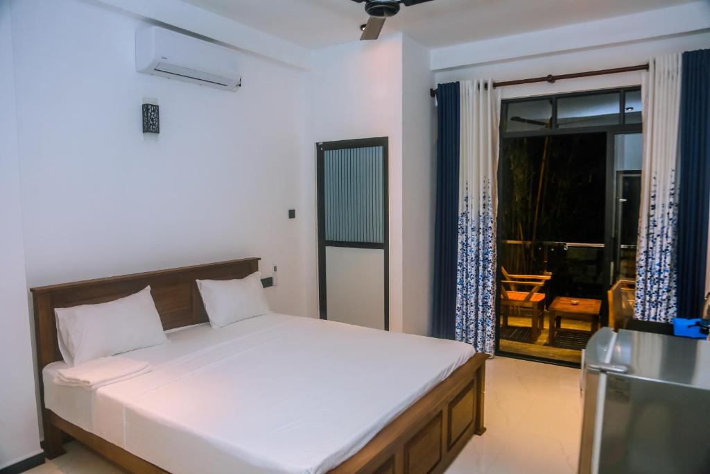 a bedroom with a bed and a view of a patio at Mirissa Breeze in Mirissa