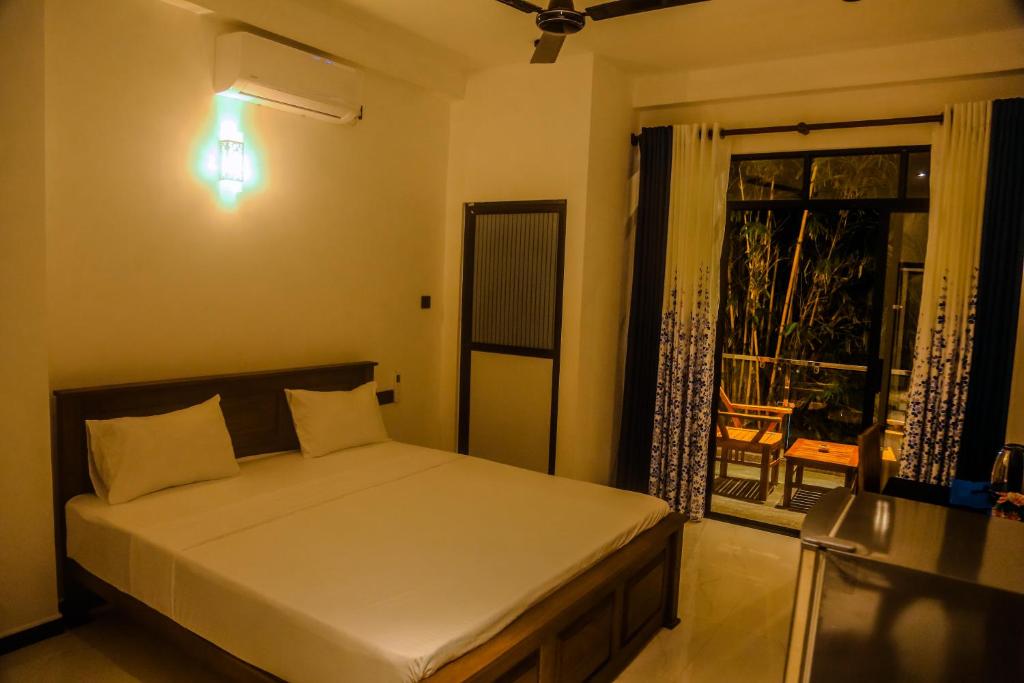 a bedroom with a bed and a window with a view at Mirissa Breeze in Mirissa