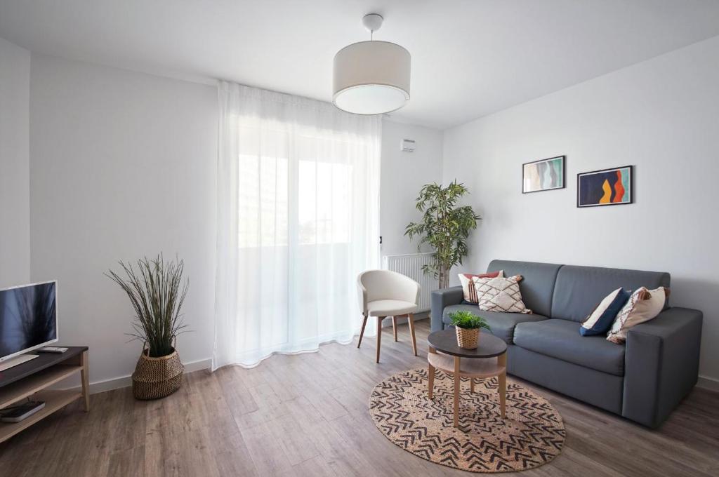 un salon avec un canapé et une table dans l'établissement Résidence Bordeaux Rive Droite, à Bordeaux