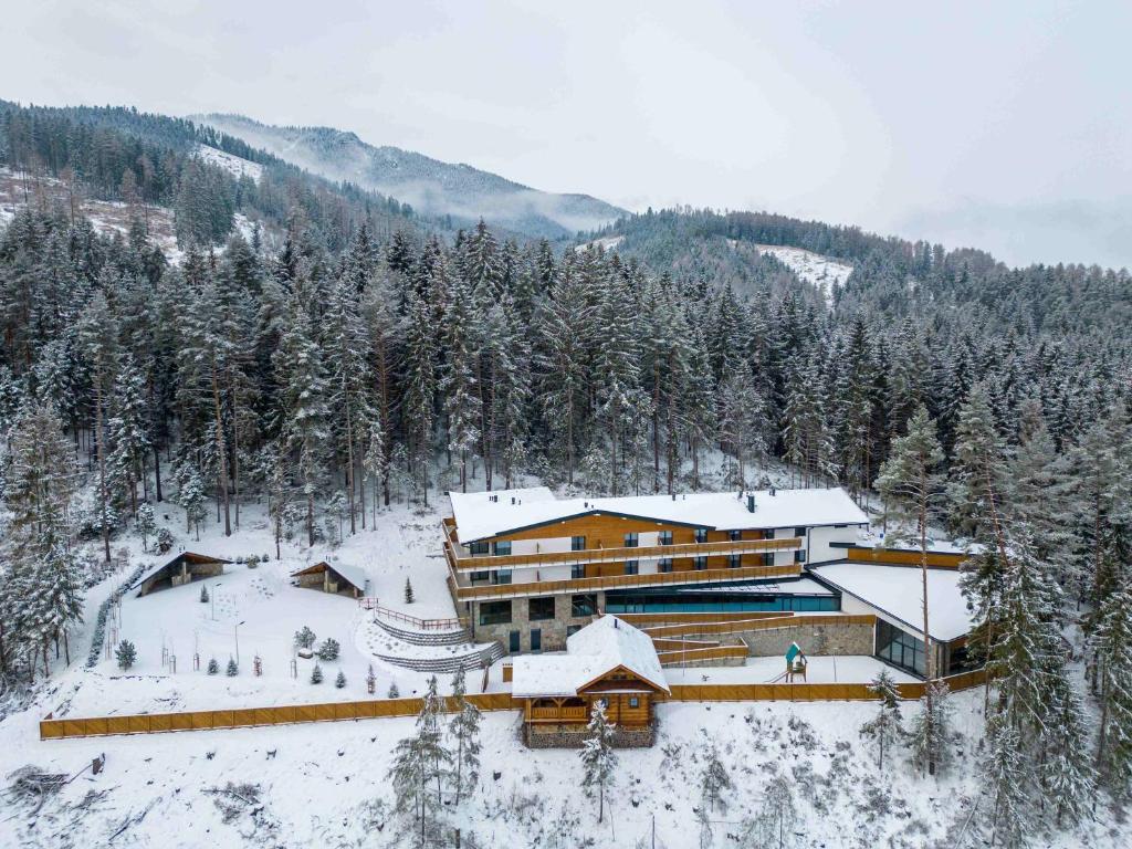 a large building in the snow with trees at Spa & Wellness Hotel Fitak**** in Liptovský Ján