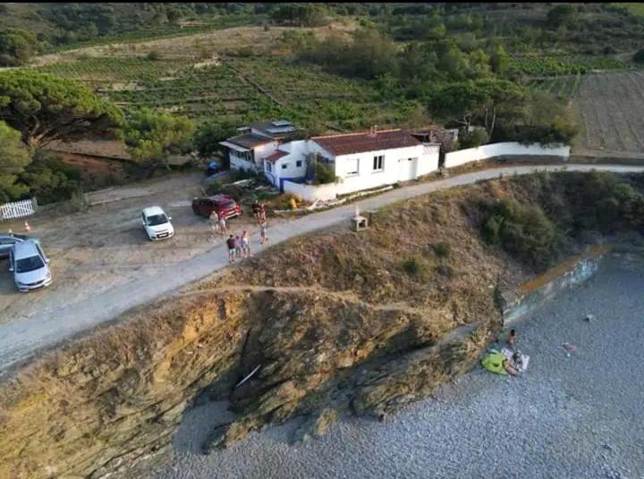 un groupe de personnes debout sur une colline avec une maison dans l'établissement Bord de Mer Paulilles, à Port-Vendres