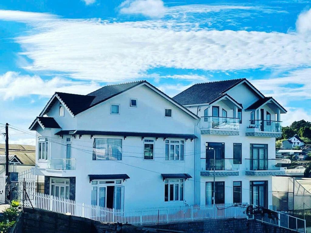 a white house with a fence in front of it at Say Homestay - Venuestay in Da Thien