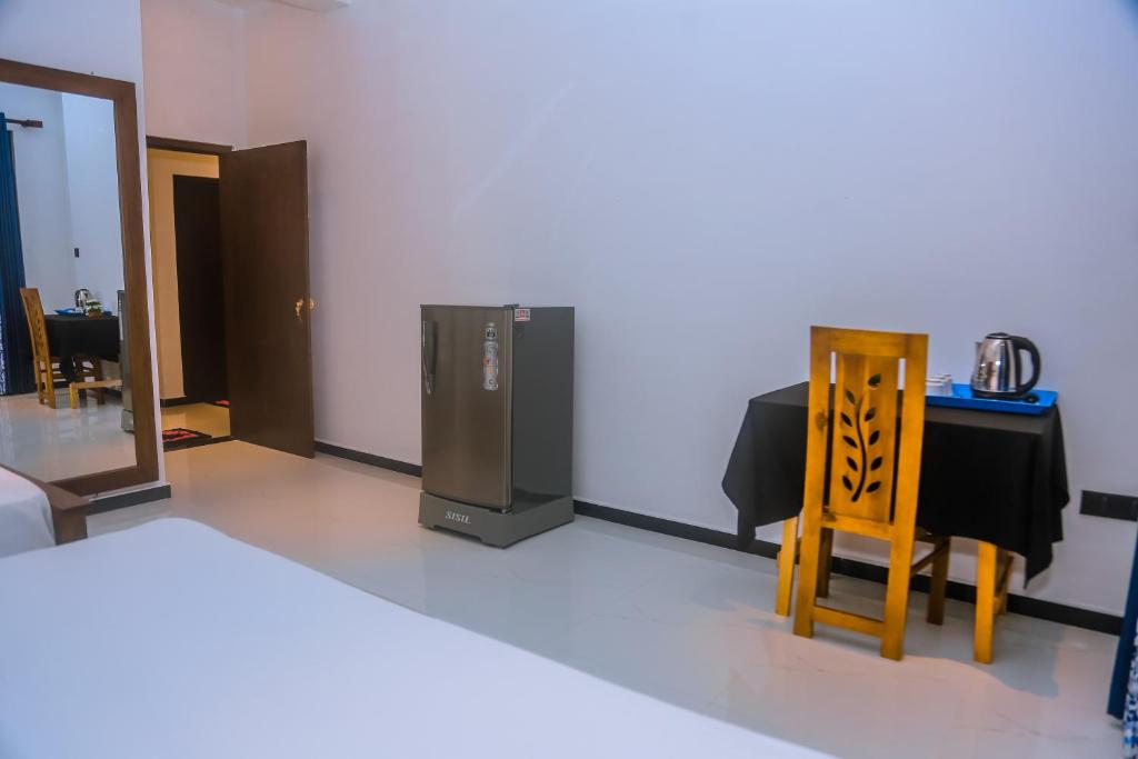 a room with a table and a refrigerator and a chair at Mirissa Breeze in Mirissa