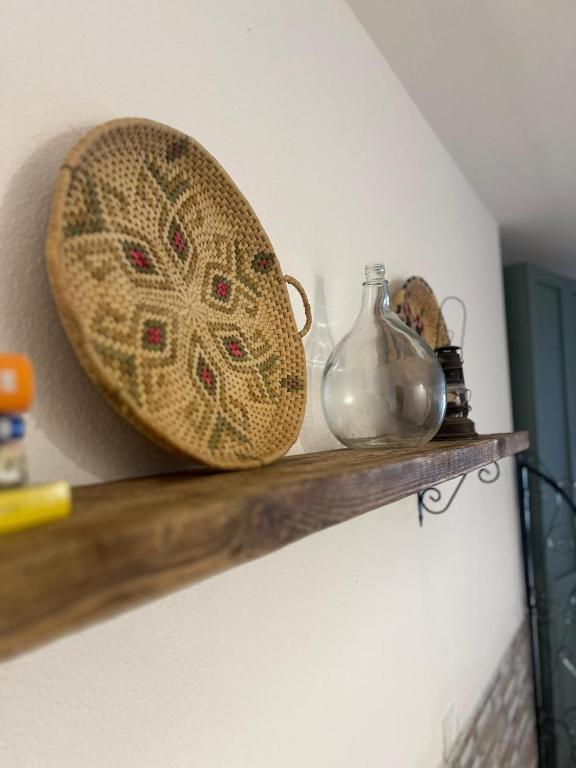 a shelf with a bowl and a glass vase on it at Tinnari home in Cascabraga