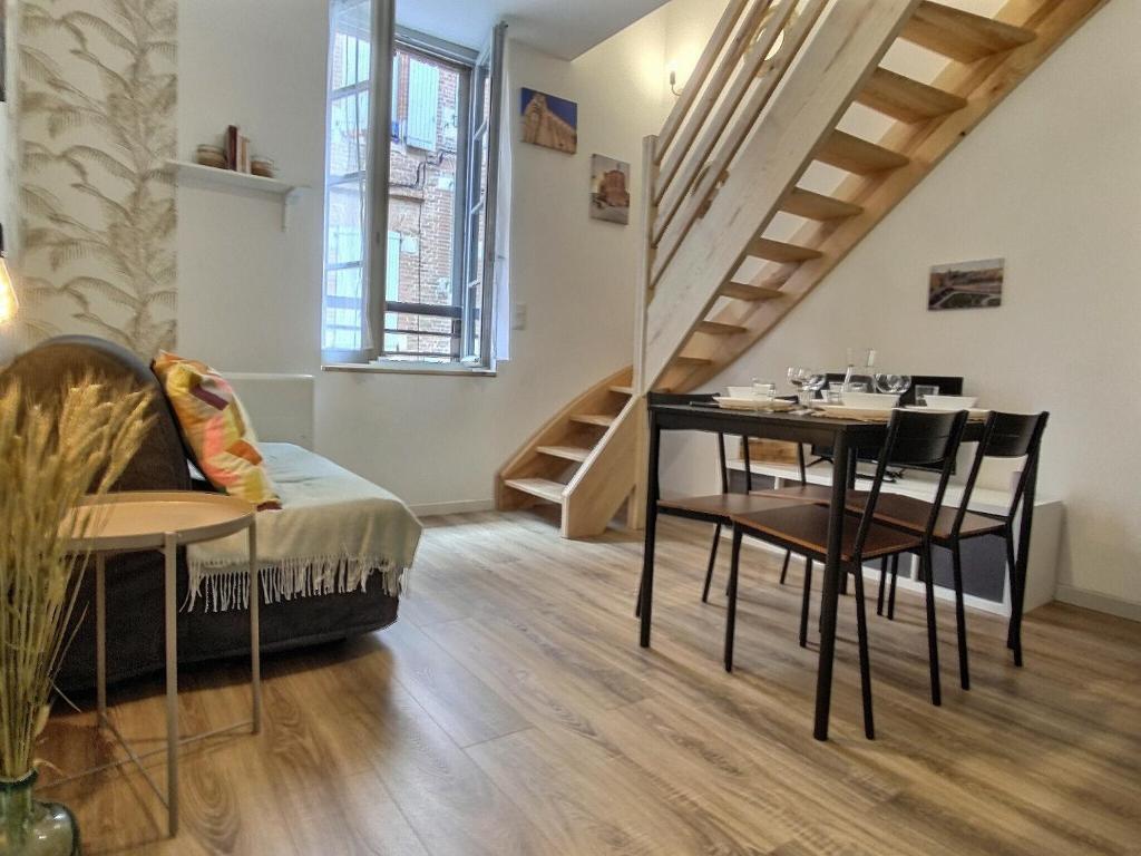 un salon avec une table et une salle à manger dans l'établissement Le Nid des Roses - Hyper Centre, à Albi