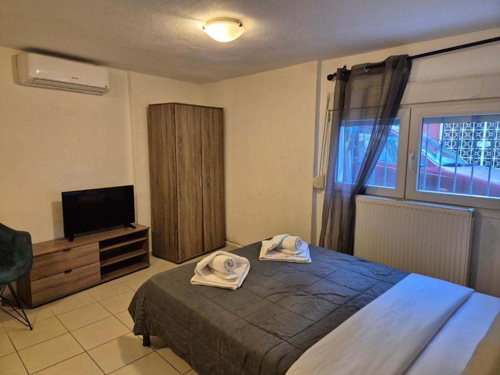 ein Schlafzimmer mit Bett und Flachbildfernseher in der Unterkunft City Studio Kavala in Kavala