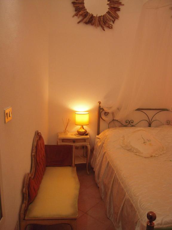a bedroom with a bed and a lamp on a table at Casa Santiago in Alassio