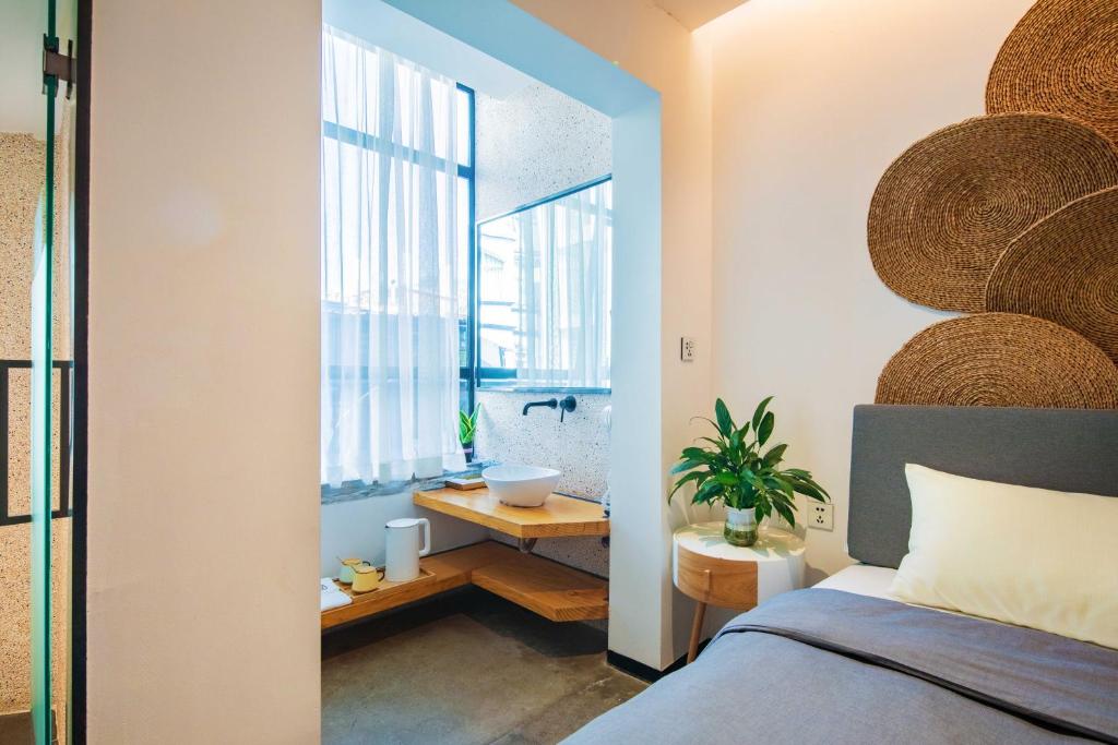 a bedroom with a bed and a bathroom with a sink at 客谈民宿Ketan Exquisite Guesthouse in Xiamen