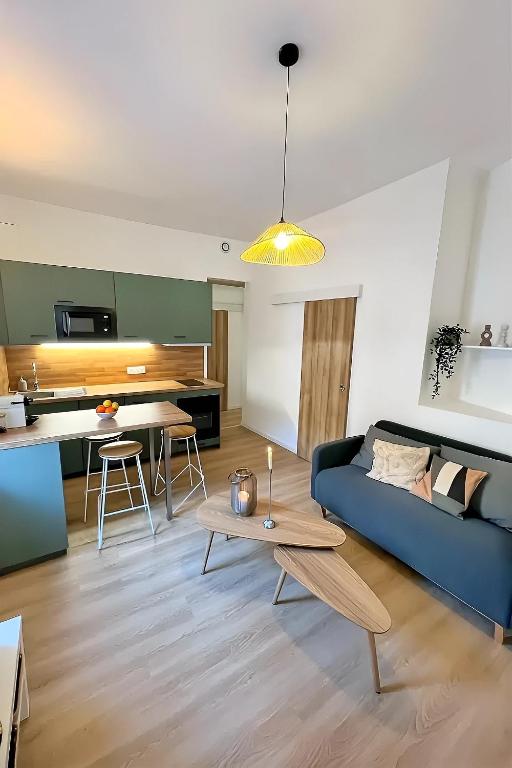 un salon avec un canapé bleu et une table dans l'établissement 2 pièces proche Arènes - Terrasse & Clim, à Nîmes