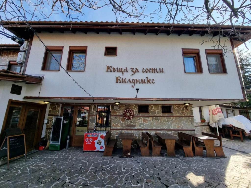 a building with a group of chairs in front of it at Къща за гости Билдникс in Malko Tŭrnovo