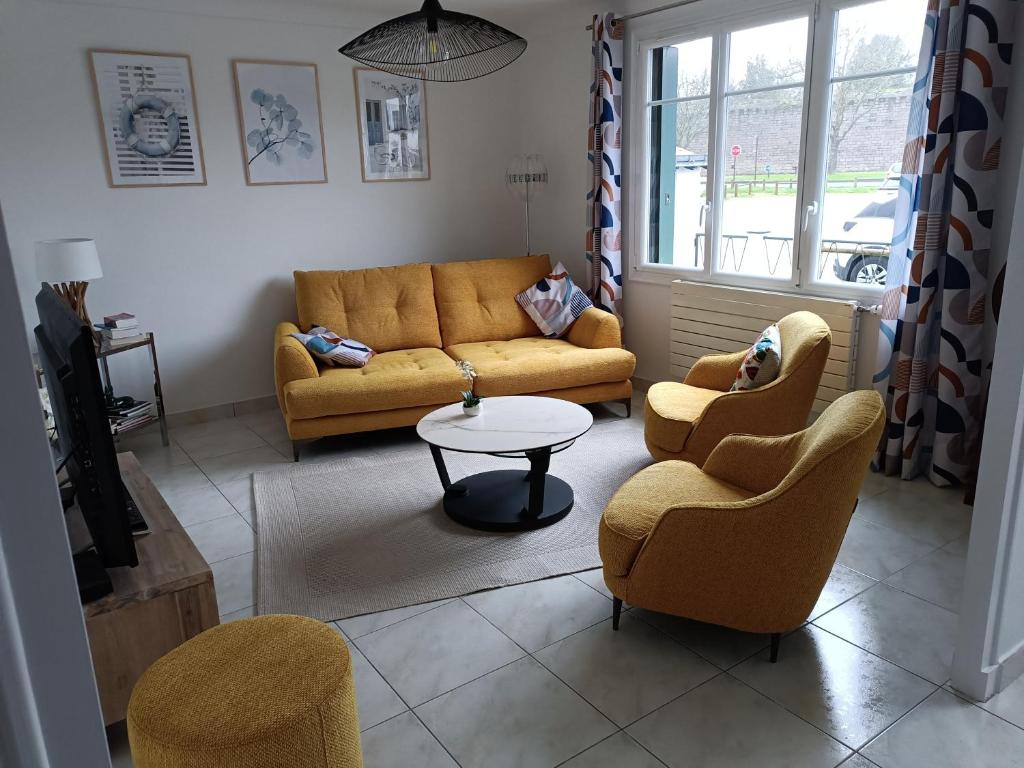 un salon avec un canapé, des chaises et une table dans l'établissement Maison de charme rénovée, à Guérande