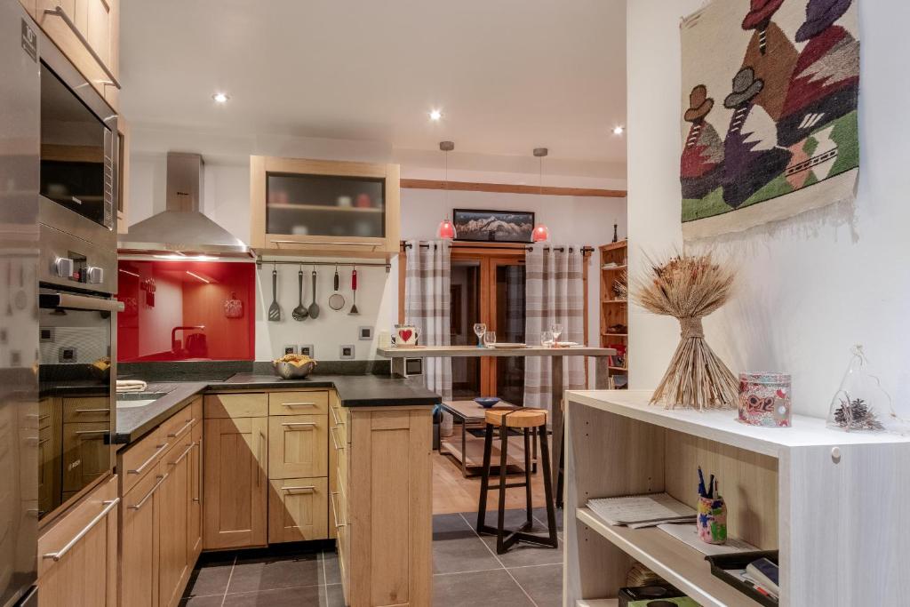 une grande cuisine avec des armoires en bois et un comptoir dans l'établissement La Cremaillere, à Sallanches