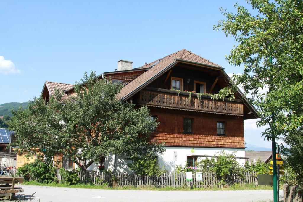 ein großes Holzhaus mit einem Zaun davor in der Unterkunft Biohof Sauschneider in Sankt Margarethen im Lungau