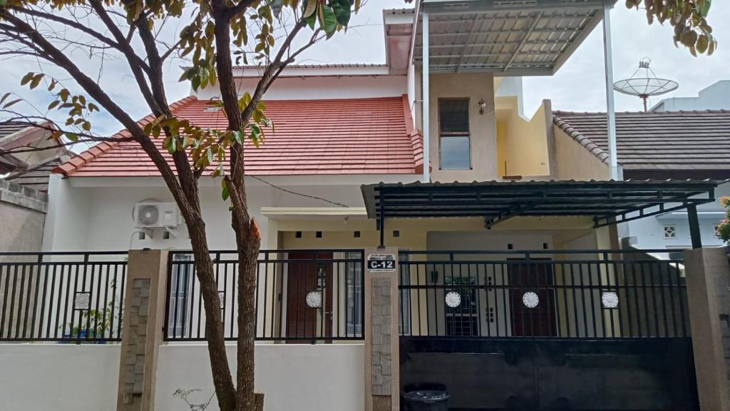 a house with a gate and a tree at Cemara Guesthouse Mataram Lombok in Mataram