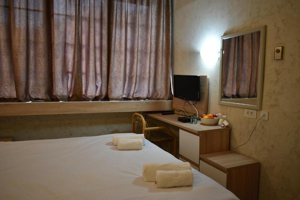 a bedroom with a bed and a desk with a television at Hotel Fersped in Mavrovo