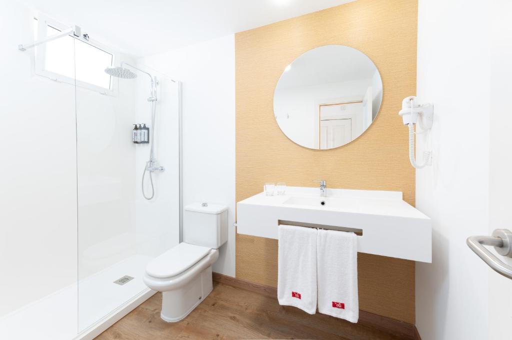 a bathroom with a sink and a toilet and a mirror at Olé Tropical Tenerife Adults Only in Playa de las Americas