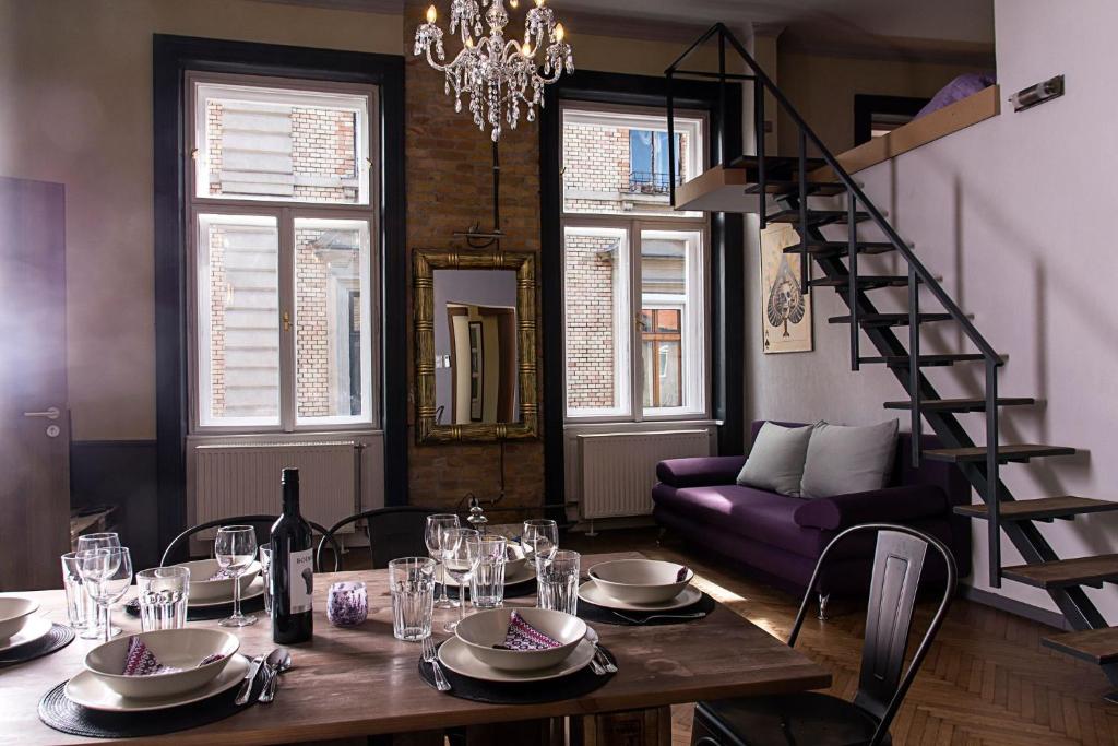 Un comedor con una mesa y un sofá morado. en New - WalnutTree Double 12 Person Apartment central in Budapest - Hungary, en Budapest