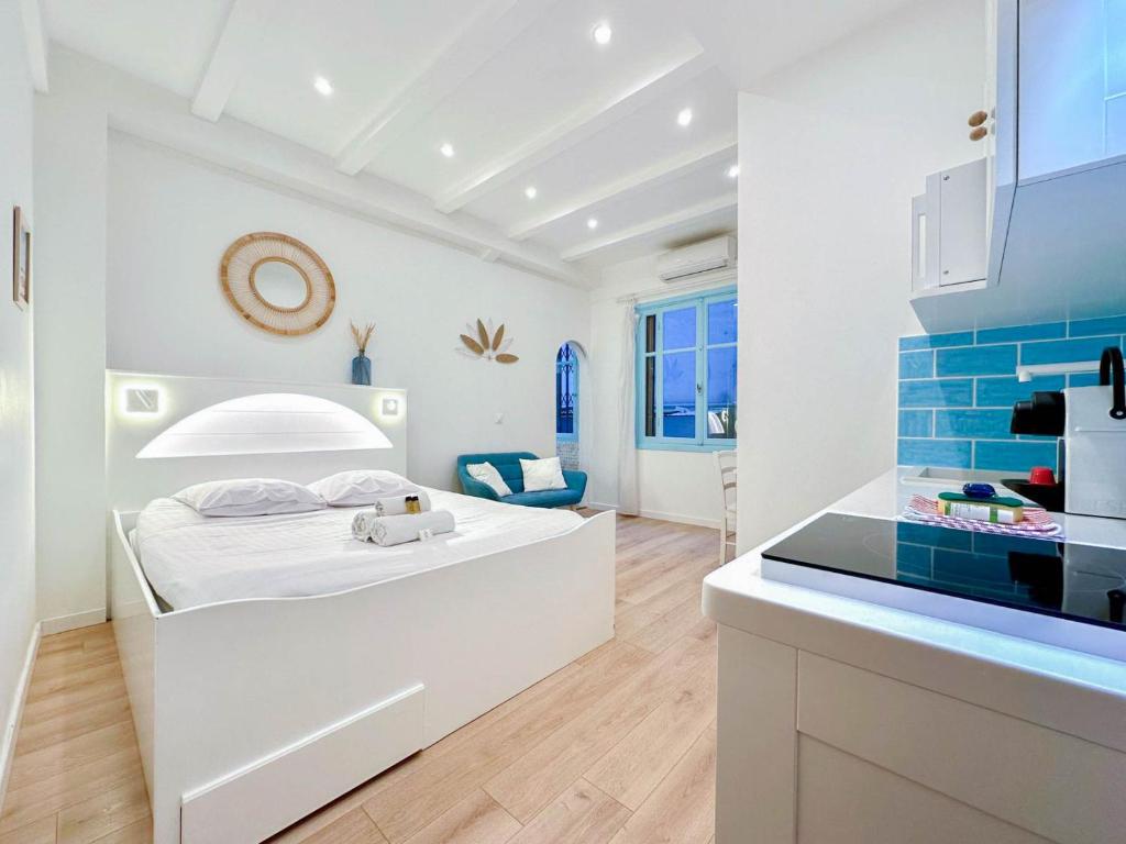Cette chambre blanche dispose d'un lit et d'une cuisine. dans l'établissement FL Joli studio cosy, proche mer et plages 3 SAINSON, à Nice