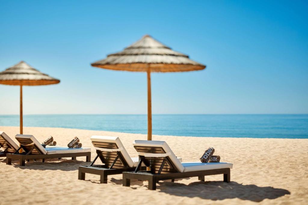 a group of chairs and umbrellas on a beach at Tivoli Marina Vilamoura in Vilamoura