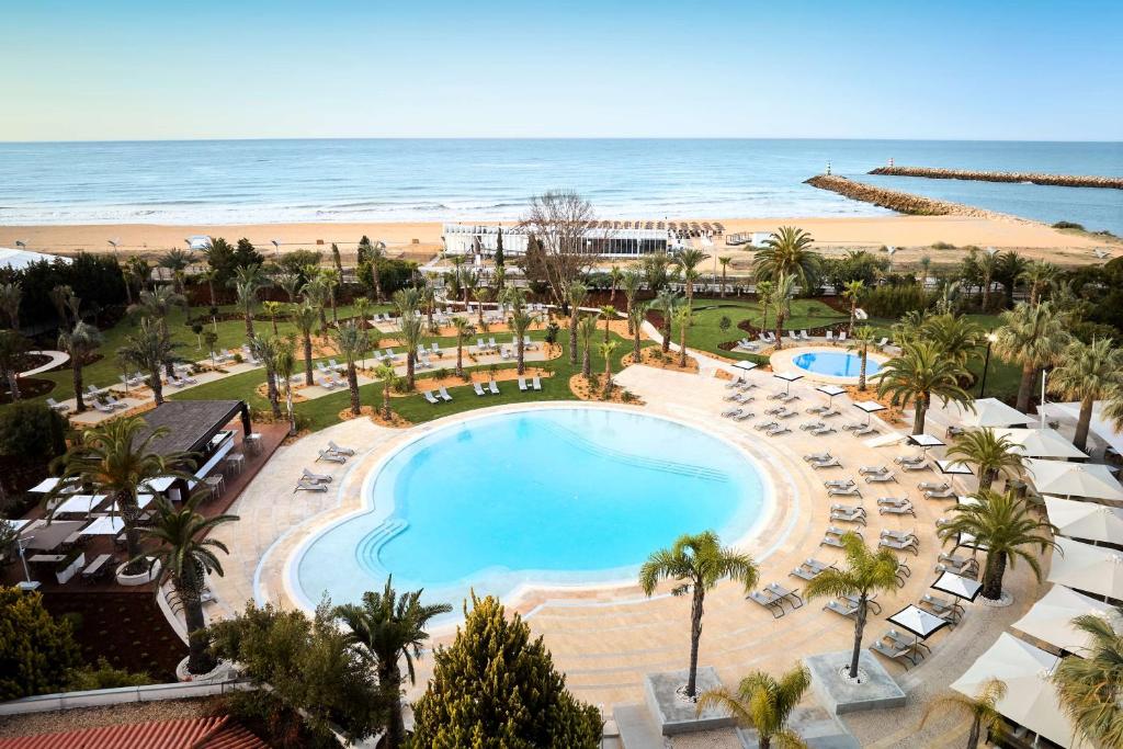 an aerial view of a resort with a pool and the beach at Tivoli Marina Vilamoura in Vilamoura