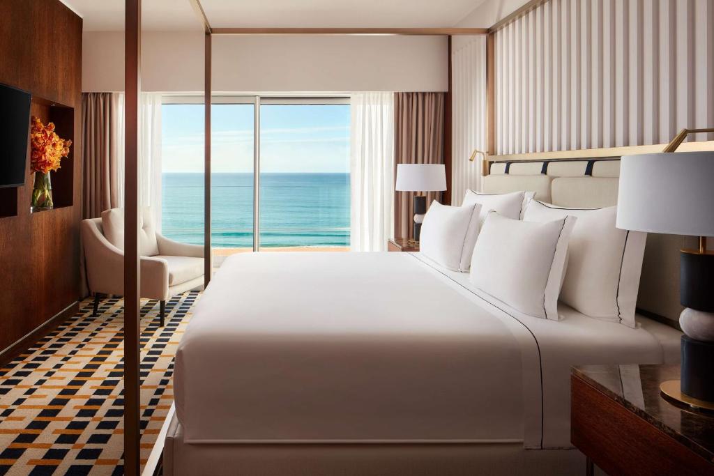 a bedroom with a large bed with a view of the ocean at Tivoli Marina Vilamoura in Vilamoura