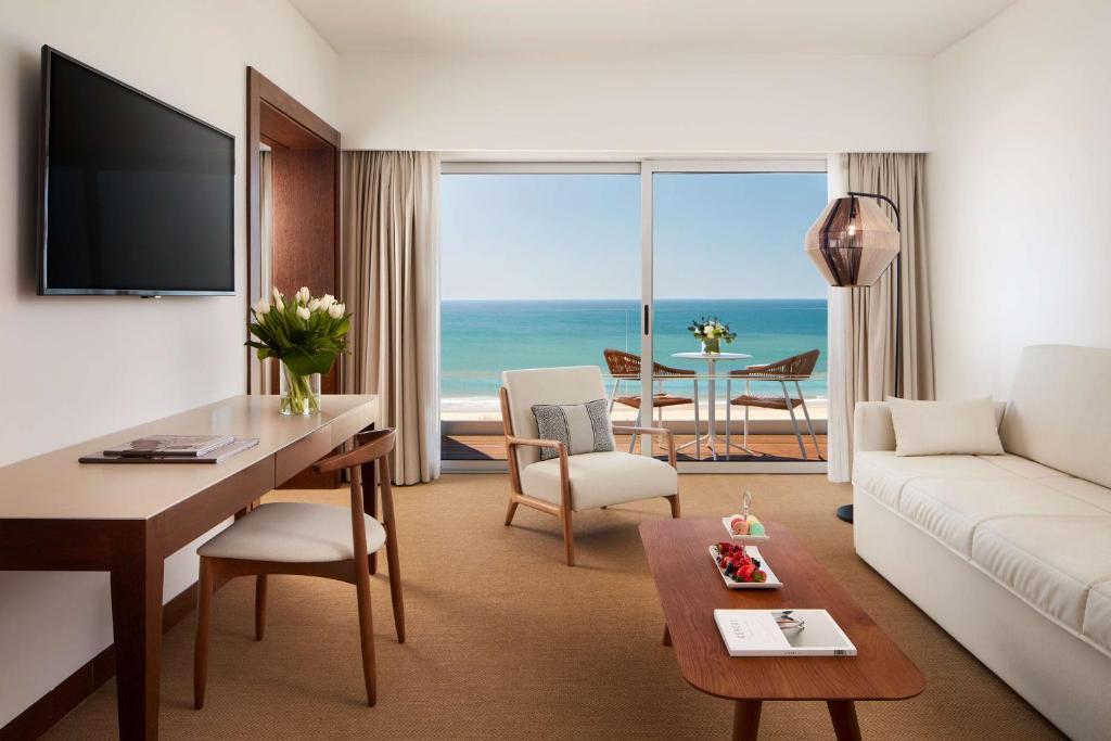 a living room with a couch and a table with a view at Tivoli Marina Vilamoura in Vilamoura