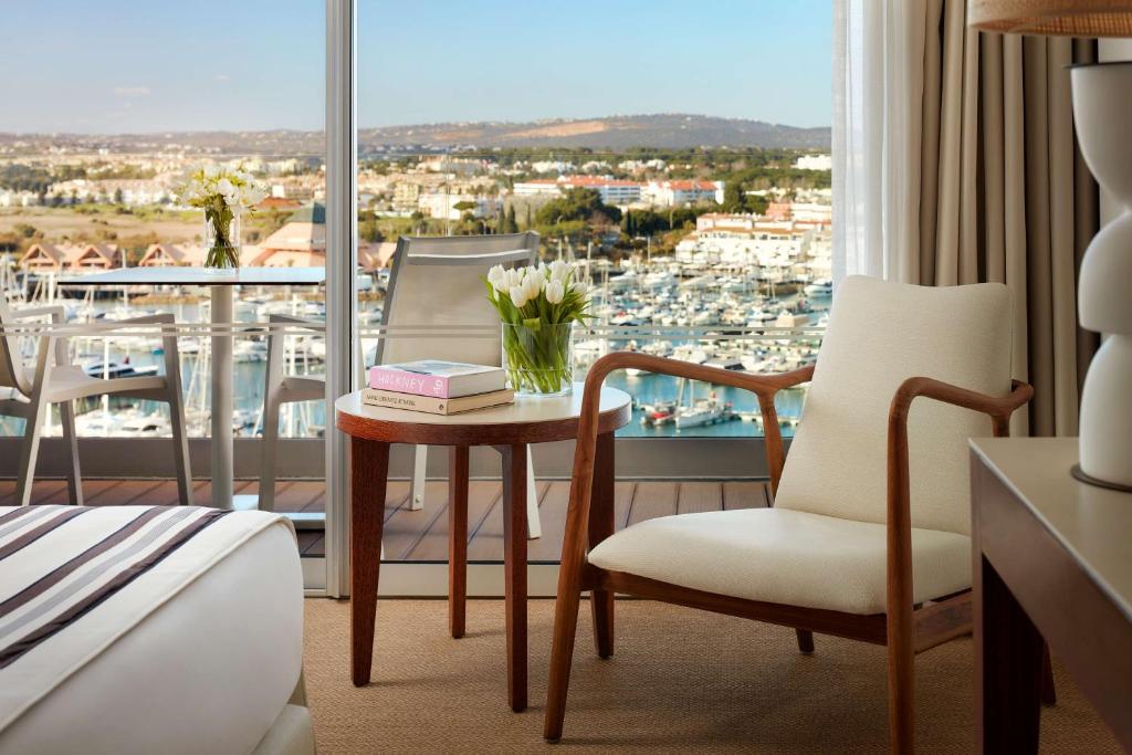 a hotel room with a bed and a table with flowers at Tivoli Marina Vilamoura in Vilamoura