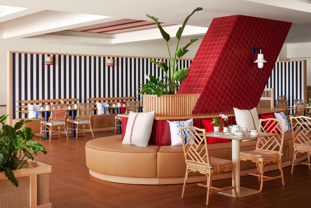 a restaurant with a couch and tables and chairs at Tivoli Marina Vilamoura in Vilamoura
