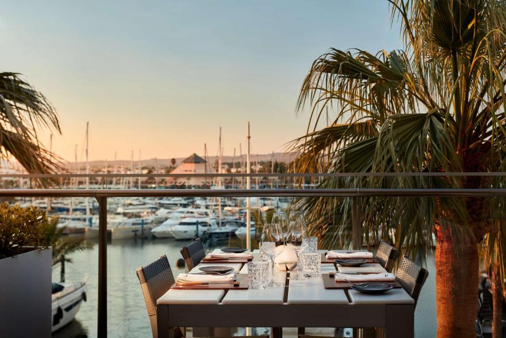 a table on a balcony with a view of a marina at Tivoli Marina Vilamoura in Vilamoura