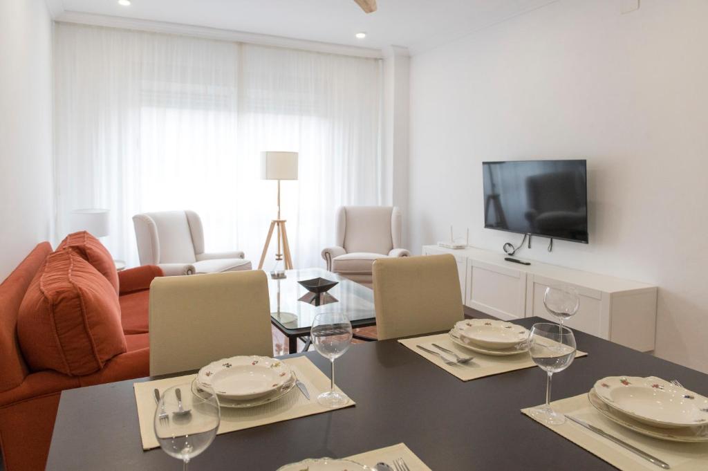 sala de estar con mesa con sillas y TV en La Bodega Con Parking Gratis, en Córdoba