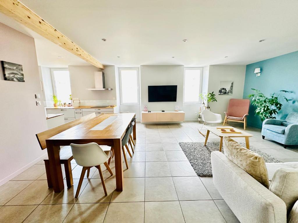 a living room with a wooden table and a couch at Appart du faubourg in Valence