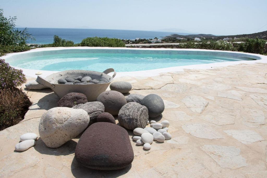 a pile of rocks sitting next to a swimming pool at Hacienda house in Andiparos
