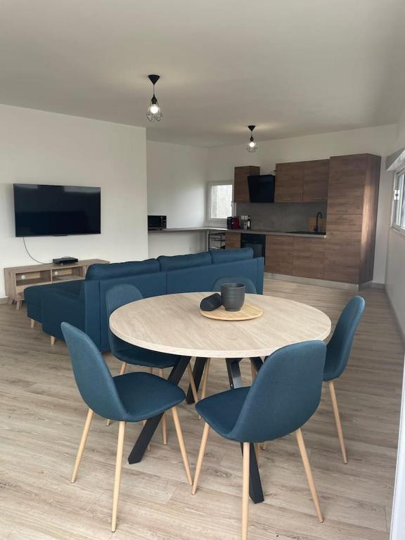 un salon avec une table et des chaises bleues dans l'établissement Jolie maison de ville atypique, à Saint-Mariens