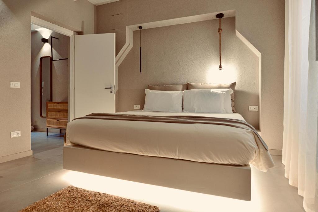 a bedroom with a large white bed with a headboard at Palermo Inn Boutique Arte in Palermo