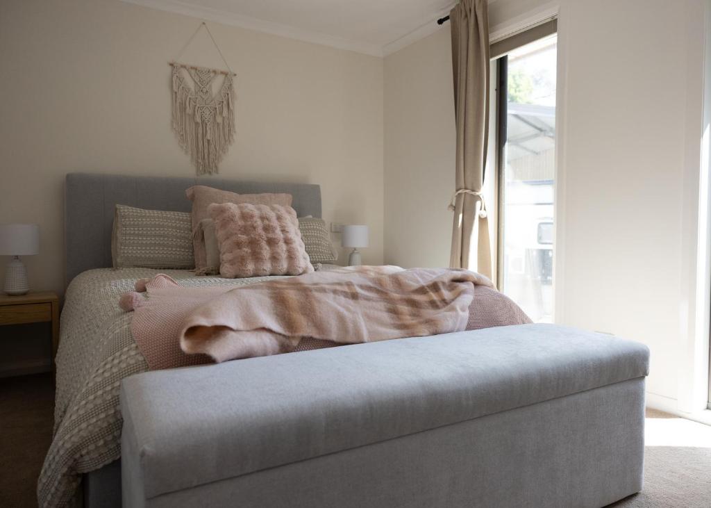 ein Schlafzimmer mit einem Bett mit einer rosa Decke darauf in der Unterkunft Five Pines Studio in Woodend