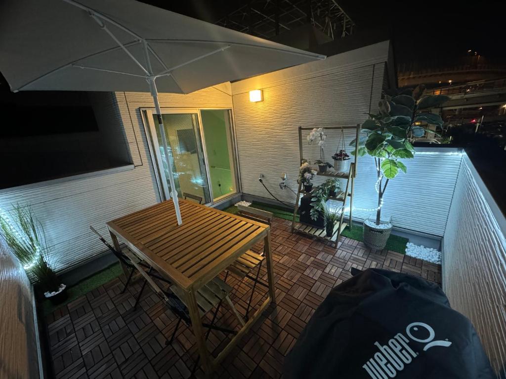 a table with an umbrella on a patio at night at Kenzo House in Kawasaki