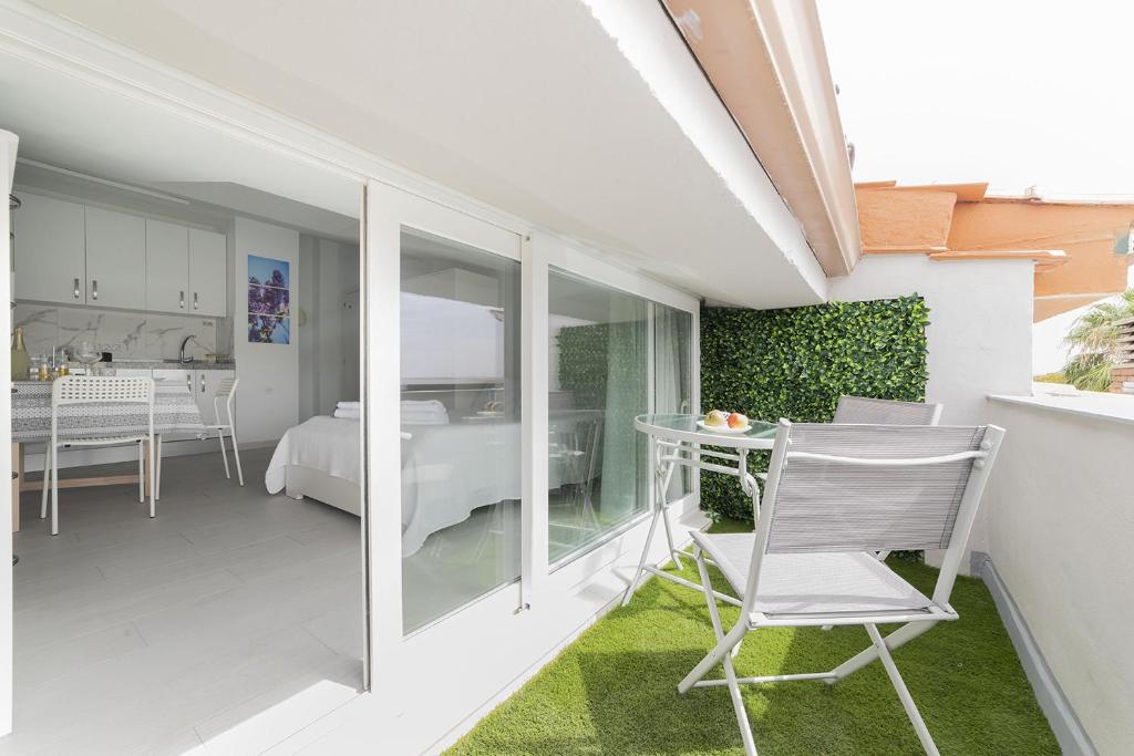 a balcony with a table and chairs in a room at Buhardilla con terraza acogedora in Coslada
