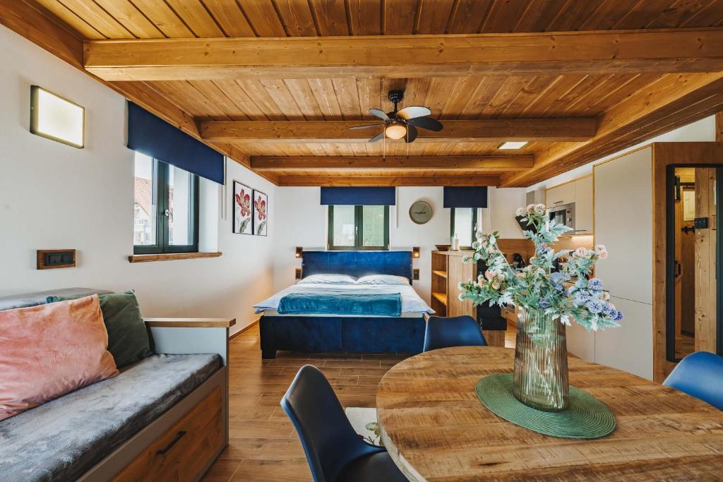 a bedroom with a bed and a table with a vase of flowers at Rezidence KUPEC in Frymburk