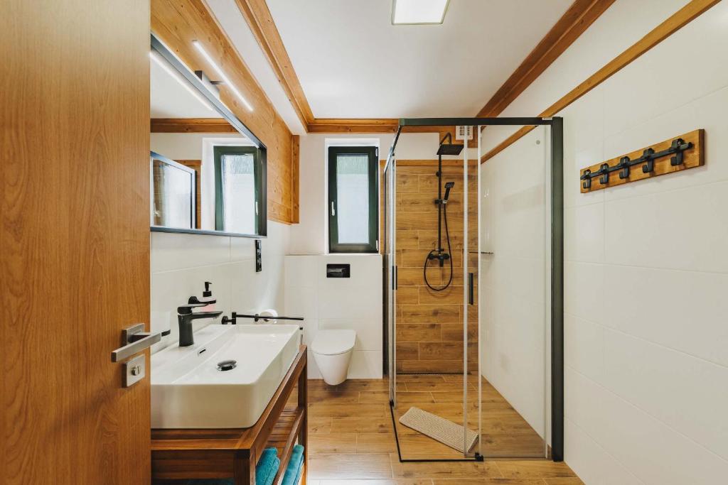 a bathroom with a sink and a shower at Rezidence KUPEC in Frymburk